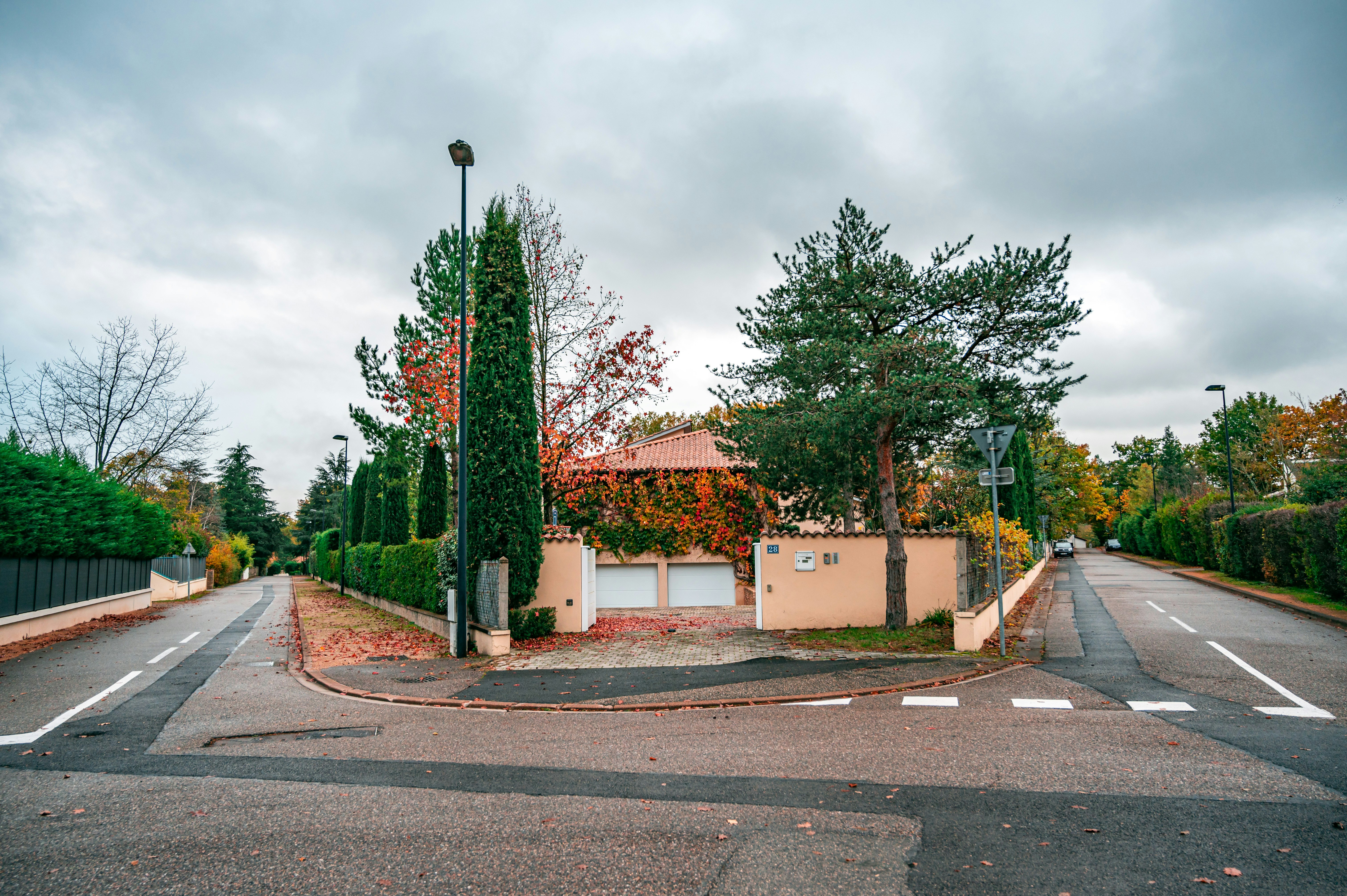 green trees beside brown and white concrete building under cloudy sky during daytime